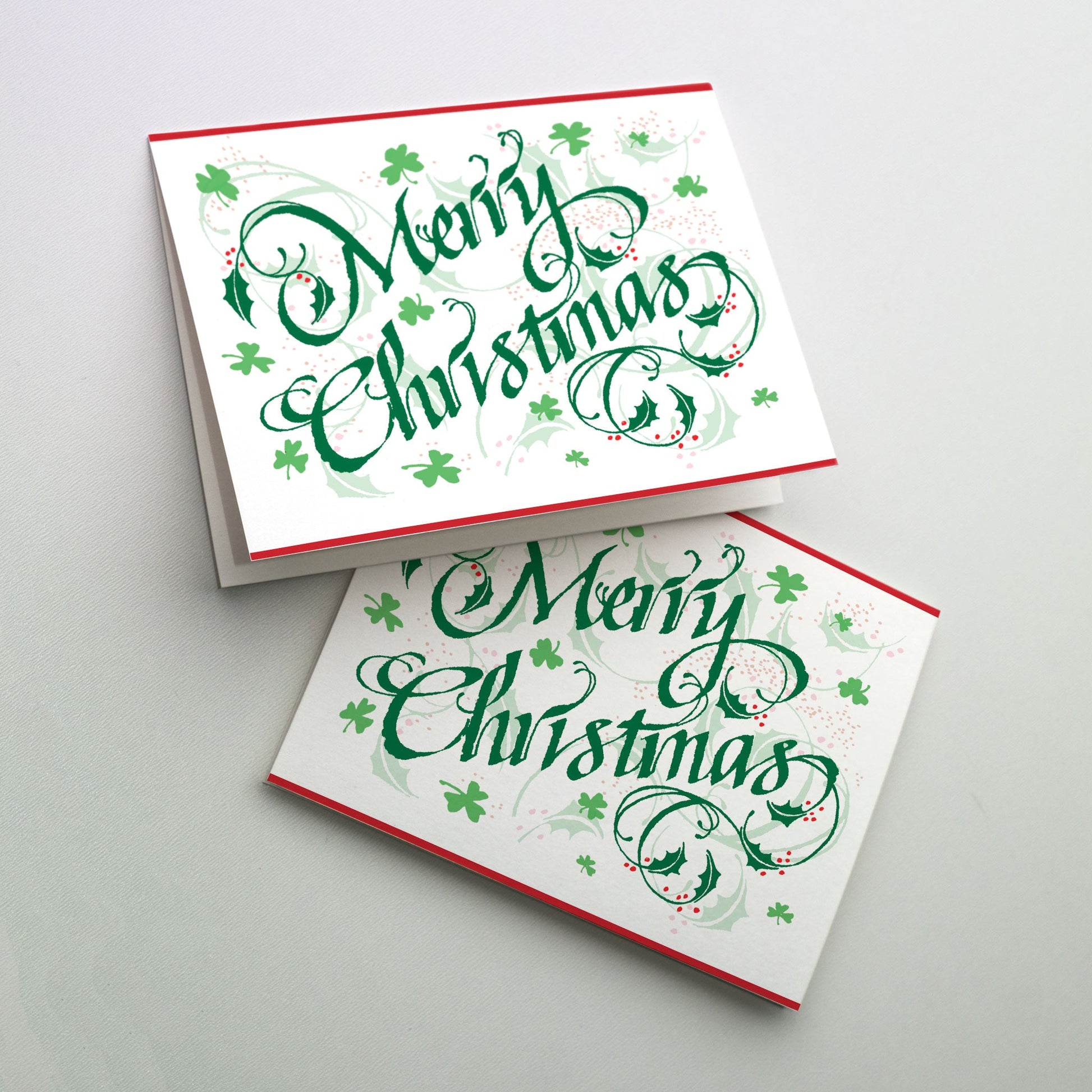 Merry Christmas in festive green lettering surrounded by holly leaves and shamrocks.