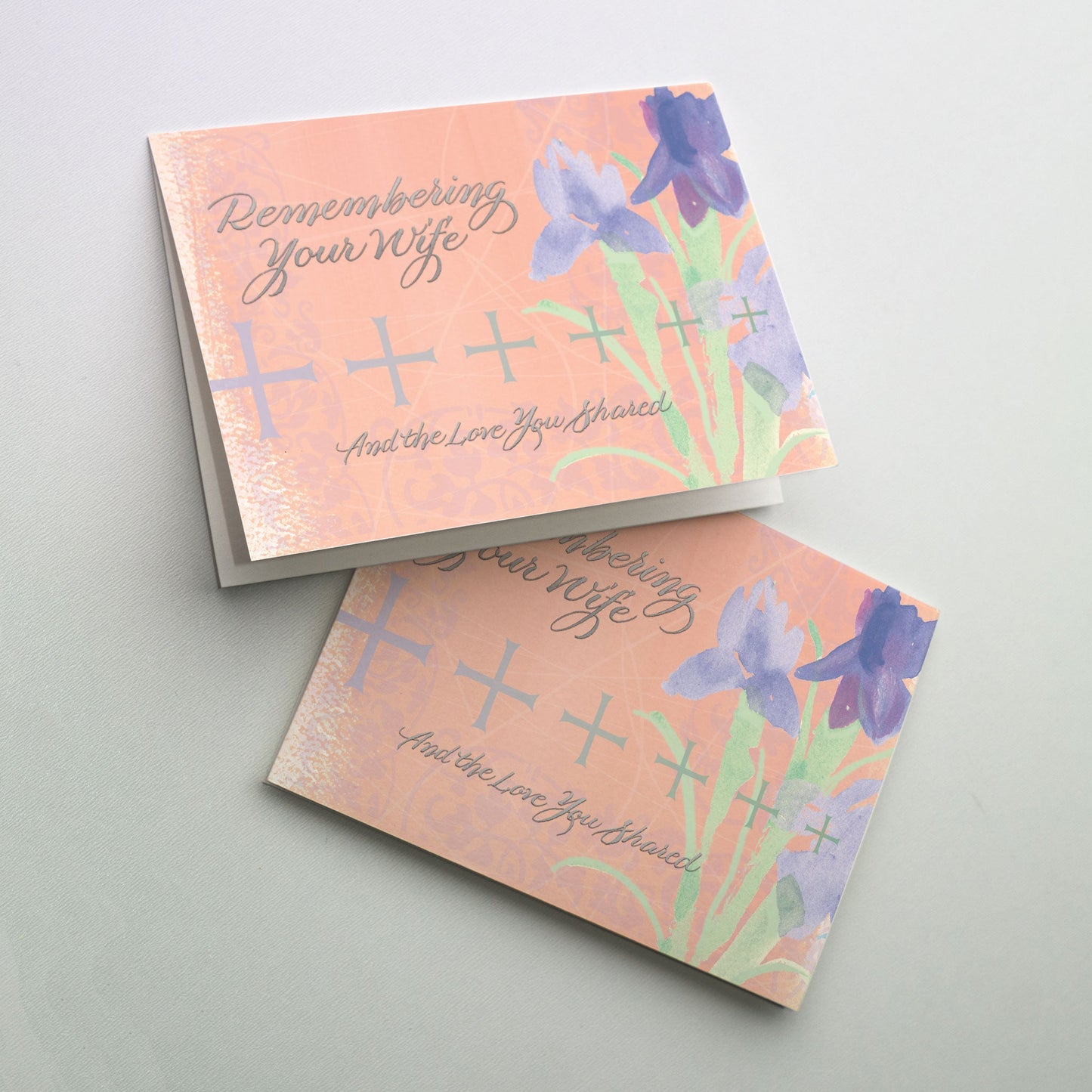 Soft pink background sets off purple iris and a cross pattern with silver metallic lettering