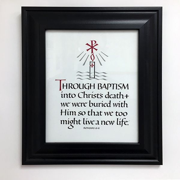 8 inch by 10 inch calligraphic framed print of Romans 6:4. The design includes a Chi-rho, lit candle, and wavy lines representing water. Beveled black frame with glass and hangers. Frame dimensions approximately 11.5 in. x 13.5 in. Appropriate as a gift for Baptism or RCIA.